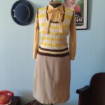 Colete vintage original dos anos 70 em crochê manual de lã listrado em branco e amarelo com acabamento marrom.