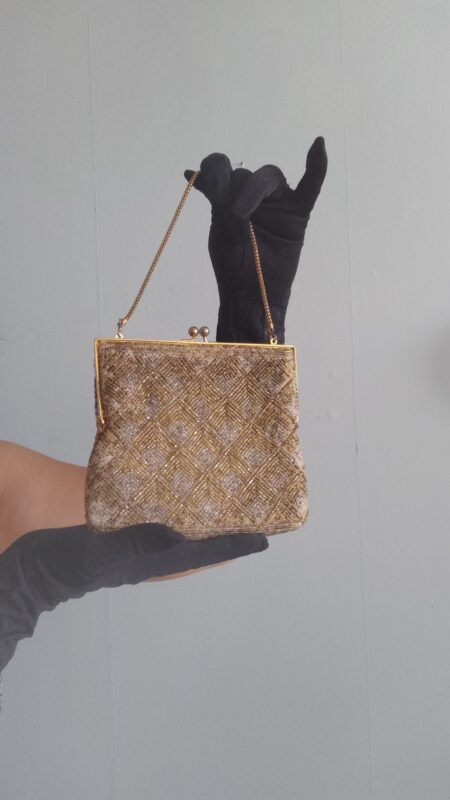Bolsa de mão vintage de festa bordada manualmente com canutilhos dourados e prateados formando desenho geométrico em losangos, com armação metálica dourada, fecho tipo kiss lock e corrente curta.