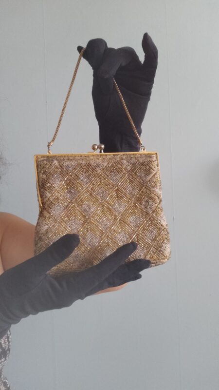Bolsa de mão vintage de festa bordada manualmente com canutilhos dourados e prateados formando desenho geométrico em losangos, com armação metálica dourada, fecho tipo kiss lock e corrente curta.