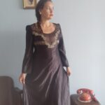 Camisola vintage preta dos anos 70 com bordado floral no busto e transparência na parte superior, modelagem longa e mangas compridas.