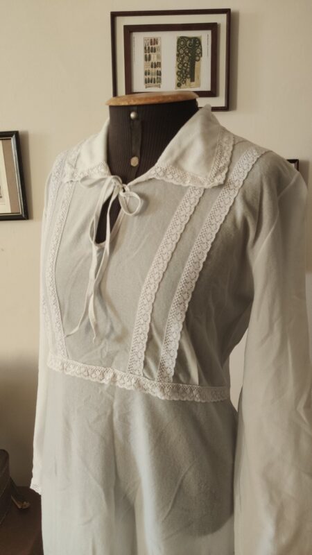 Camisola vintage azul claro dos anos 70/80 em tecido pele de pêssego, com renda frontal, gola ampla e mangas longas, exibida em manequim