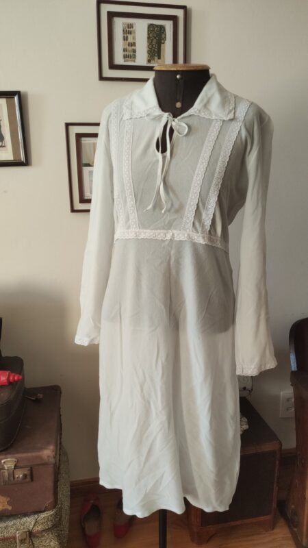 Camisola vintage azul claro dos anos 70/80 em tecido pele de pêssego, com renda frontal, gola ampla e mangas longas, exibida em manequim