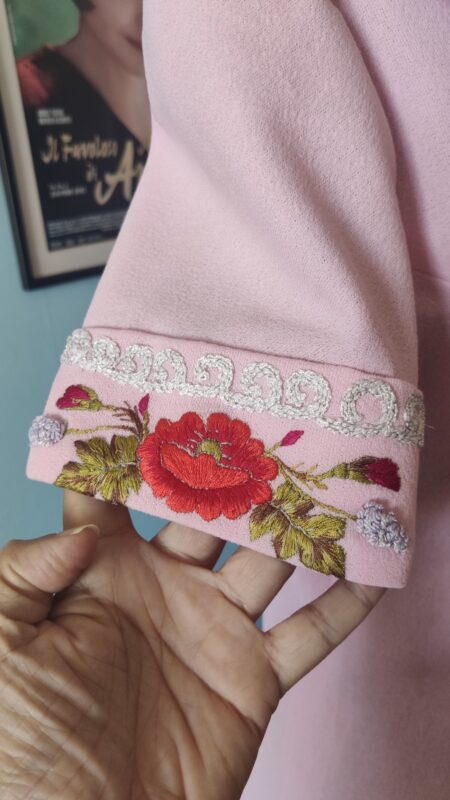 Camisa vintage original dos anos 70 na cor rosa com mangas curtas, botões forrados e bolsos frontais bordados com flores feitas à mão. Peça confeccionada por costureira em tecido sintético, com ricos detalhes artesanais e acabamento sofisticado típico da moda vintage.