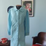 Penhoar vintage original dos anos 70 na cor azul celeste, confeccionado em tecido pele de pêssego com detalhes matelassê. Modelo felpudo com mangas longas, bolsos laterais e abotoamento frontal com botões forrados. Peça vintage feminina em excelente estado de conservação, ideal para o inverno.