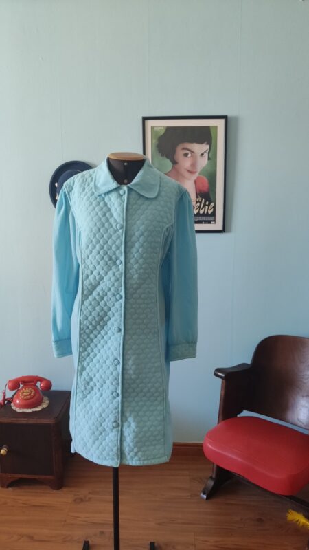 Penhoar vintage original dos anos 70 na cor azul celeste, confeccionado em tecido pele de pêssego com detalhes matelassê. Modelo felpudo com mangas longas, bolsos laterais e abotoamento frontal com botões forrados. Peça vintage feminina em excelente estado de conservação, ideal para o inverno.