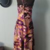 Vestido longo vintage original dos anos 70 com estampa psicodélica em tons de roxo, lilás, bege e amarelo. Modelo de alças finas com aplicações de lantejoulas e caimento fluido. Peça feita por costureira em tecido sintético com forro, fotografada em manequim em ambiente interno com decoração retrô.