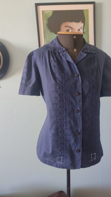 Blusa vintage original dos anos 80 em algodão azul-marinho, com bordado inglês frontal, gola trabalhada, mangas levemente bufantes e botões frontais.