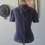 Blusa vintage original dos anos 80 em algodão azul-marinho, com bordado inglês frontal, gola trabalhada, mangas levemente bufantes e botões frontais.