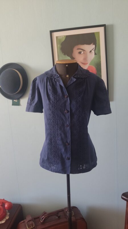 Blusa vintage original dos anos 80 em algodão azul-marinho, com bordado inglês frontal, gola trabalhada, mangas levemente bufantes e botões frontais.
