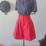 Saia-calça vintage original dos anos 80 em linho misto vermelho, cintura alta, pregas frontais, bolsos e fechamento por botão frontal.