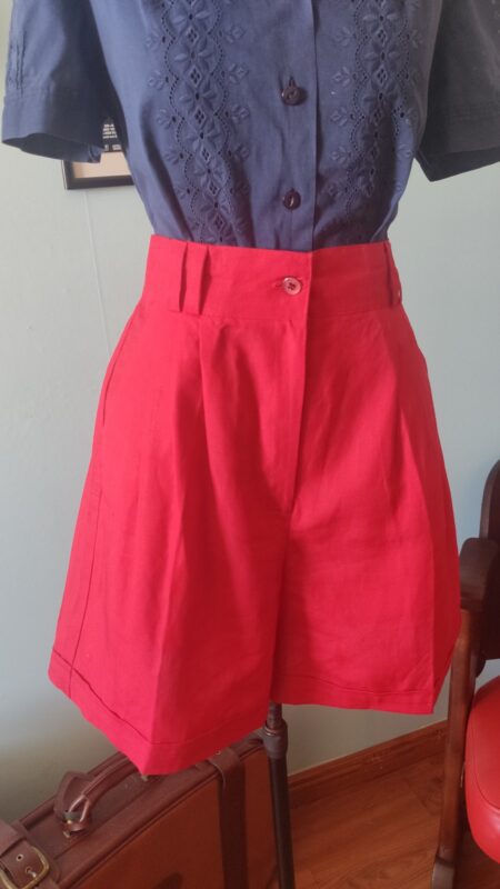 Saia-calça vintage original dos anos 80 em linho misto vermelho, cintura alta, pregas frontais, bolsos e fechamento por botão frontal.
