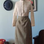 Saia lápis vintage original em lã com estampa pied-de-poule preta e cinza, comprimento midi e fenda traseira.