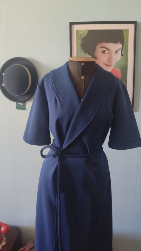 Vista frontal de vestido vintage anos 80 azul-marinho com modelagem acinturada e bolso lateral.