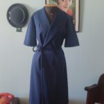 Vestido vintage azul-marinho transpassado com faixa na cintura e saia evasê.