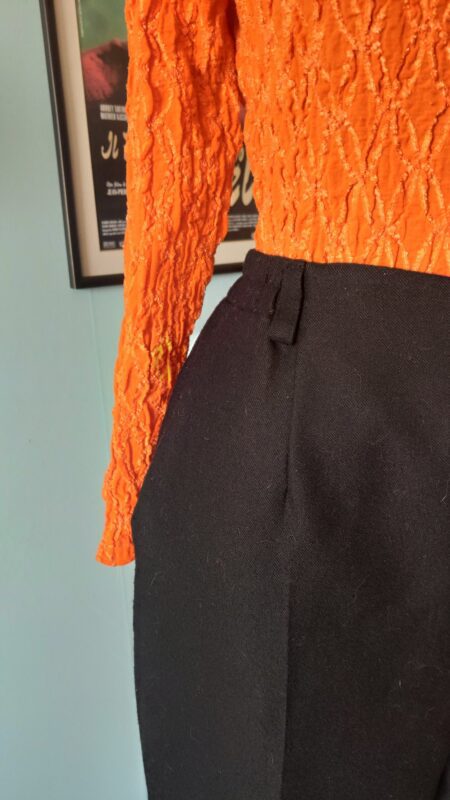Detalhe do cós da calça Jar-Mod, mostrando o fechamento frontal por botão e zíper, além dos elásticos embutidos nas laterais que proporcionam melhor ajuste ao corpo.