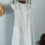 Camisola vintage provável anos 80 em azul-claro, usada em modelo, com ampla pala de bordado inglês, babados e fechamento frontal por botões.