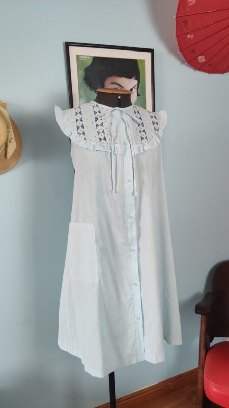 Camisola vintage provável anos 80 em azul-claro, usada em modelo, com ampla pala de bordado inglês, babados e fechamento frontal por botões.