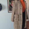 Casaco vintage original dos anos 1970 confeccionado em lã com estampa xadrez Príncipe de Gales, modelagem alongada, lapela clássica e bolsos frontais com lapela.