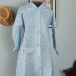 Penhoar vintage original dos anos 70 em azul e branco, com estampa quadriculada, gola arredondada, mangas longas e um bolso frontal.