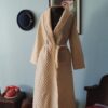 Penhoar vintage Trianon em matelassê creme, longo, com gola xale, mangas compridas e faixa para amarração na cintura.