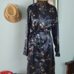 Penhoar vintage anos 90 em cetim azul-marinho com estampa floral colorida, gola xale, mangas longas e faixa para amarração.