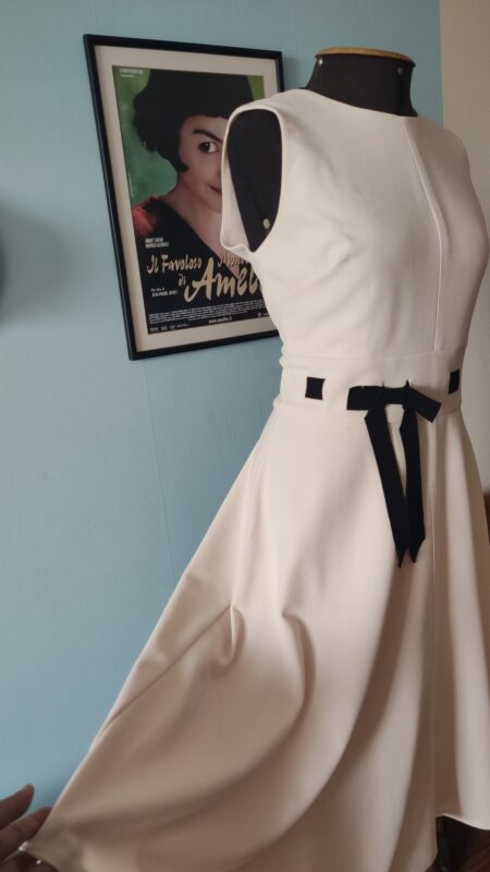 Detalhe da saia godê do vestido Calvin Klein Dress, mostrando a amplitude da modelagem evasê, o caimento estruturado do tecido e o acabamento elegante da peça.
