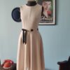 Vestido Calvin Klein Dress original em tom off white, com modelagem fit and flare, cintura marcada por fita de gorgurão formando um laço e saia godê. Peça de design minimalista, confeccionada em poliamida e poliéster.