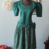Vestido vintage verde dos anos 80 em tafetá, com mangas volumosas, cintura marcada, grande laço lateral e saia de renda floral.