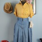 Saia jeans vintage original dos anos 80, azul, de cintura alta e modelagem ampla, combinada com camisa amarela.