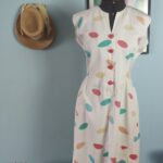 Vestido vintage dos anos 80 em algodão branco com estampa de formas coloridas, cintura marcada e saia ampla.
