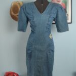 Vestido jeans vintage EMA dos anos 80, azul, com decote V, ombreiras, mangas volumosas e modelagem ajustada.