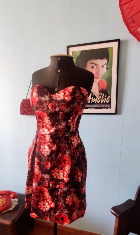 Vestido contemporâneo tomara que caia da marca SSANG BANG WOOL, com bojo, decote coração, cintura marcada e estampa floral vermelha sobre fundo preto.