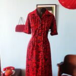 Vestido vintage Apeninos dos anos 1970, com fechamento frontal por botões, mangas três quartos e saia ampla estampada em vermelho e azul-marinho