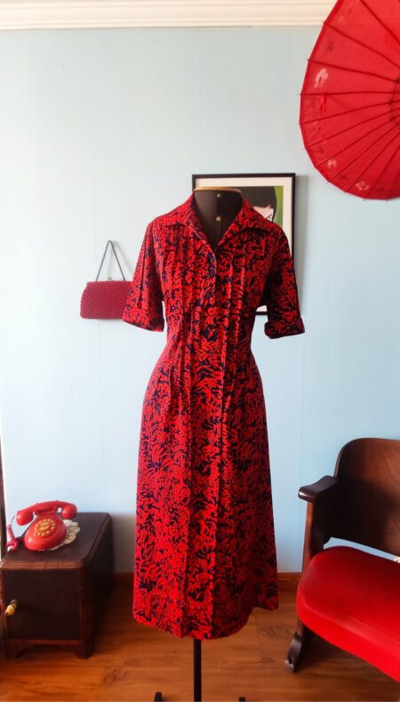 Vestido vintage Apeninos dos anos 1970, com fechamento frontal por botões, mangas três quartos e saia ampla estampada em vermelho e azul-marinho